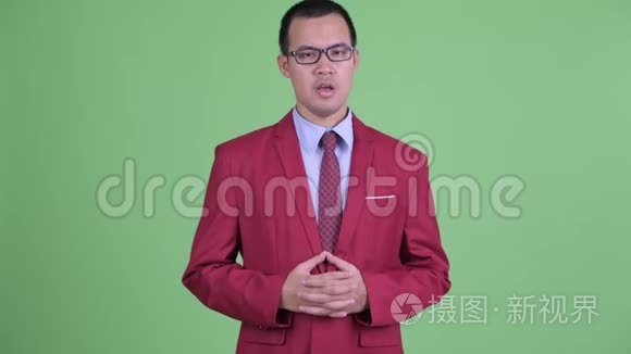 快乐的亚洲商人带着眼镜解释着什么