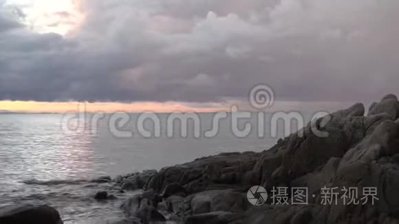 粉色天空在时间点模式，拍摄到海洋背景和石头前景。