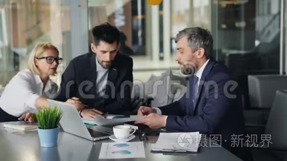 愤怒的商人在咖啡馆里和伙伴们聊天，看着扔报纸的图表