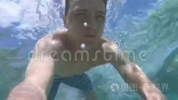 年轻人在蓝色干净的水里潜水视频
