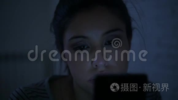 一个30多岁的西班牙裔年轻女子，躺在床上，深夜用手机看着，侧着侧着的平底锅