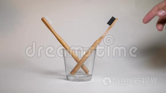 夫妻俩把木制牙刷放在玻璃杯里。 没有塑料意识的极简主义生活方式。