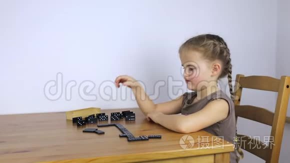 坐在桌边玩多米诺骨牌的女孩视频