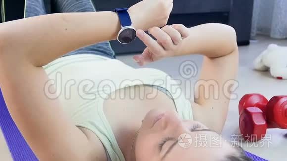 年轻女子在做运动前手腕上使用健身追踪器的慢动作镜头