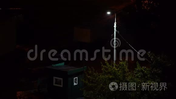 一盏灯在雨夜的城市里闪烁。 电力问题。 恐怖之夜。 雨夜闪烁的路灯.. 看法