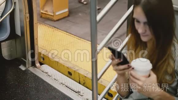 高角度相机在吸引年轻的欧洲妇女在地铁列车使用智能手机，车门关闭在站台。