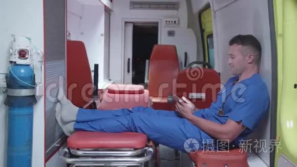 男人坐在救护车里，看着什么，微笑着。