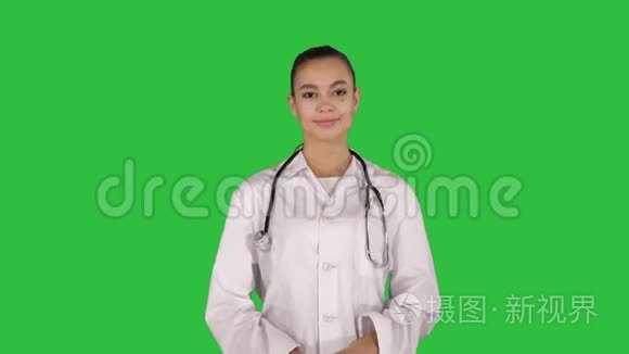 年轻的医生女士在绿色屏幕上展示和显示产品或文本，Chroma键。