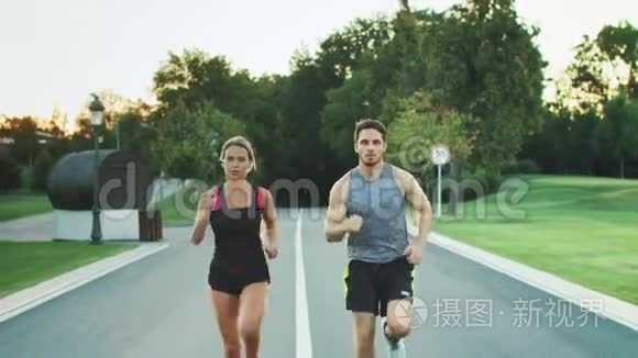 体育夫妇在公园里一起跑步。 年轻人一起慢跑