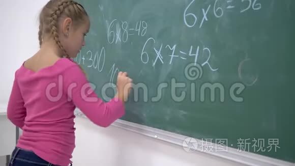 小学教育，女生用粉笔在班级绿色黑板上解决数学问题