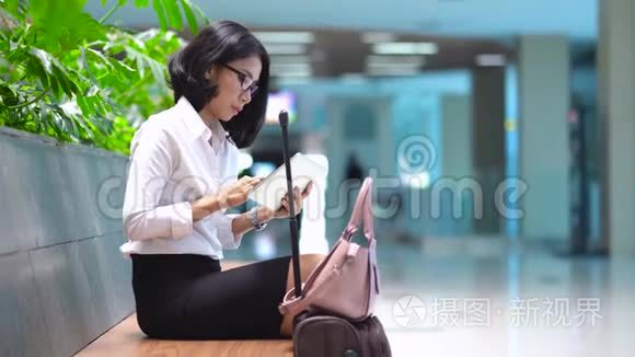 女商人在火车站用平板电脑视频