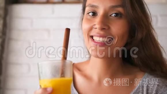 迷人的年轻微笑混合女孩喝芒果和素食超级食品冰沙饮料。4K慢动健康生活方式理念。
