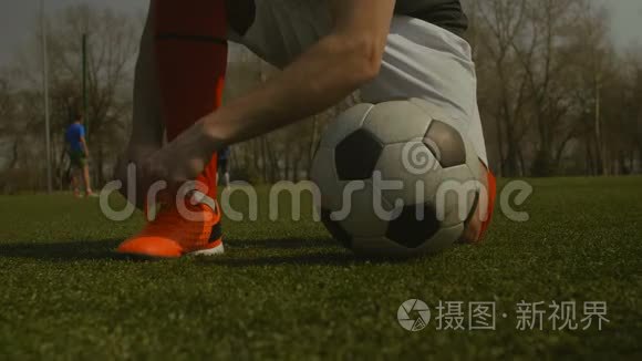 足球运动员在足球场上系鞋带视频