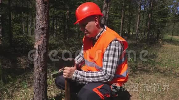 伐木工人在森林里磨斧子视频