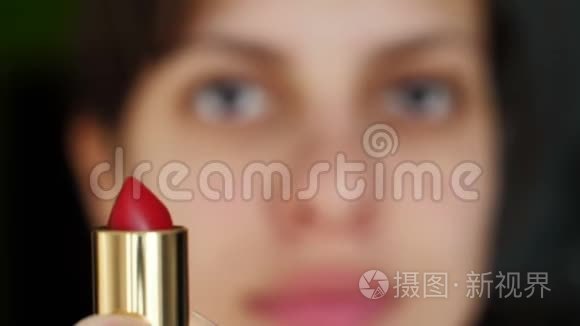 年轻的女人拿着红色的口红视频