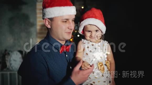 快乐的一家人头戴圣诞老人帽，戴着闪闪发光的首饰，在圣诞树下微笑