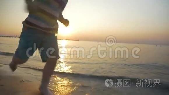 赤脚小孩日落时在海水中奔跑视频