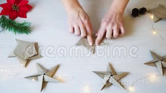女性手折折纸明星圣诞装饰的时间流逝