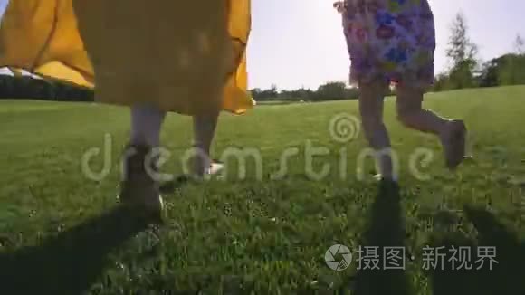 妈妈和女孩赤脚在草地上奔跑视频