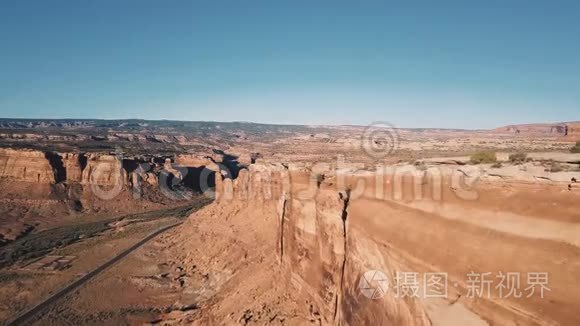 无人机飞在巨大的沙漠山脉旁边，揭示了令人叹为观止的岩石峡谷悬崖，开放的空间和天际线。