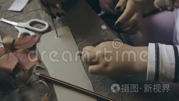 妈妈带着孩子用纸和树叶做手工视频