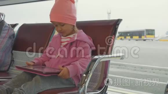 儿童在机场出发时观看平板电脑视频