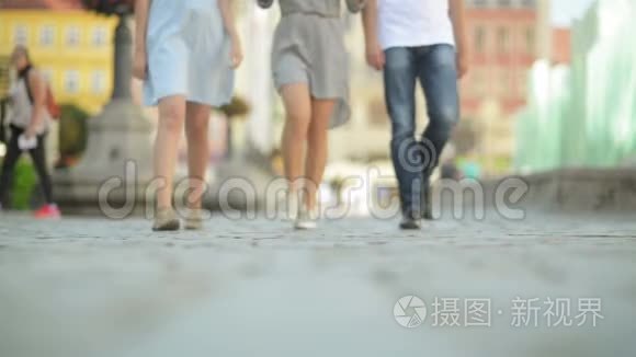 三个朋友在中午的人行道上散步. 他们在这晴朗炎热的天气里玩得很开心.