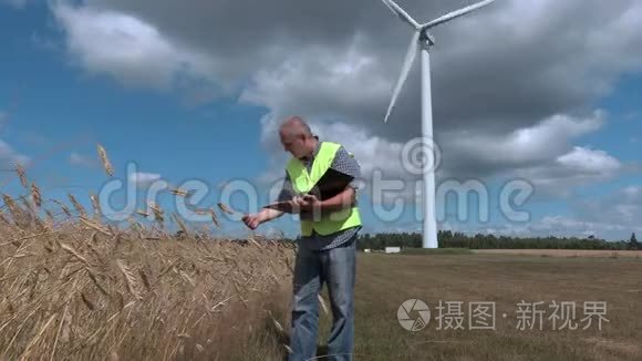 农民在风力涡轮机附近检查谷物视频