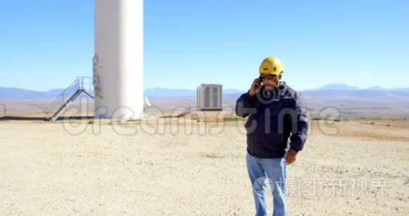 男工程师在风电场用手机通话视频