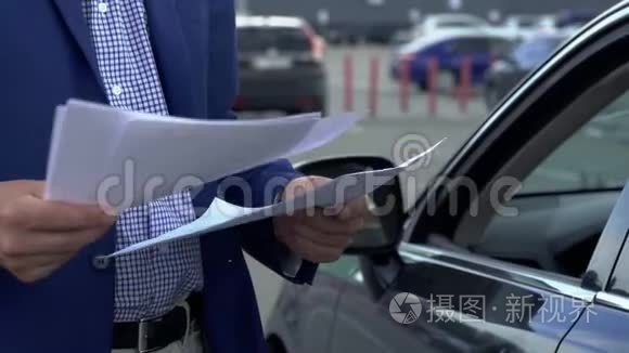 商人正站在汽车旁翻阅商业文件视频