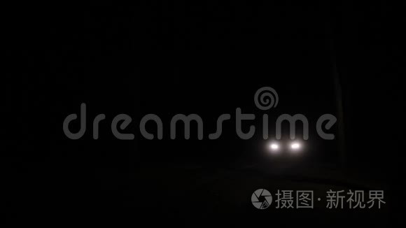 汽车的大灯在黑暗的道路上接近视频