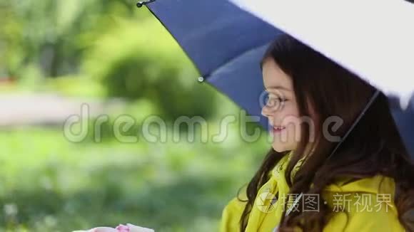 小女孩拿着伞在雨中玩耍视频