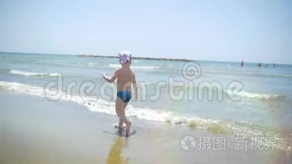 赤脚在沙滩上奔跑的小男孩视频