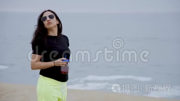 美丽的女孩走在海边的沙滩上视频