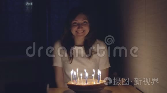 年轻女子在节日蛋糕上吹蜡烛视频