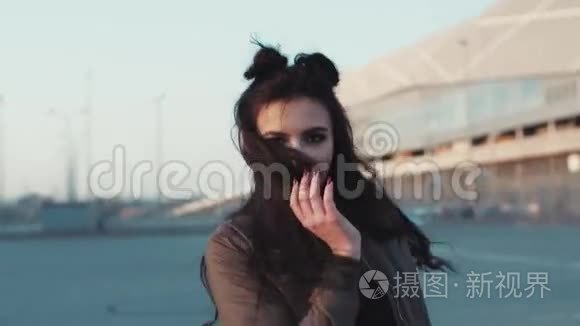 迷人的年轻女人，化妆自然，玩弄她的头发，迷人的微笑，并继续行走。 愉悦的心情