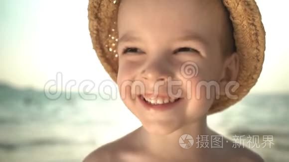 海滩上戴草帽的可爱男孩肖像视频