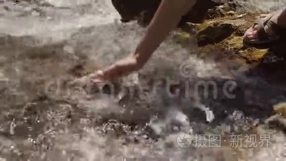 女孩在干净的山间小溪里打水视频