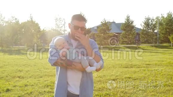 一个男人把他的儿子抱在户外视频