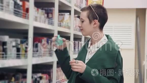 在超市里选择香水的年轻女子视频