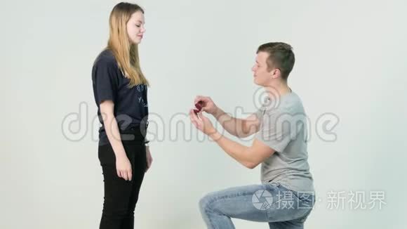 向女友求婚的年轻人。 男人跪在年轻女子面前，向女孩求婚