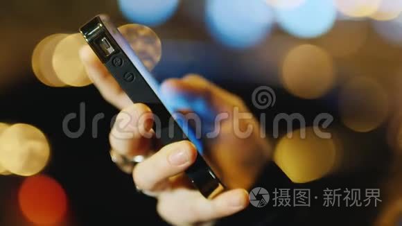 在灯光模糊的背景下用手拿手机视频