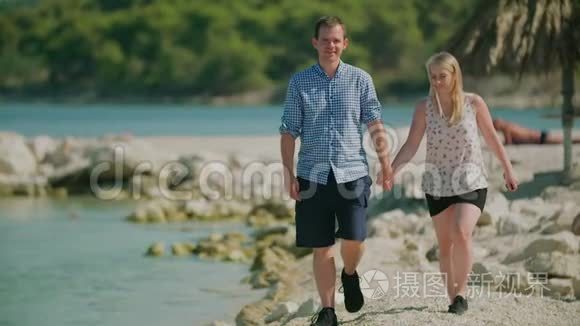 一对夫妇手牵着手在沙滩上散步视频