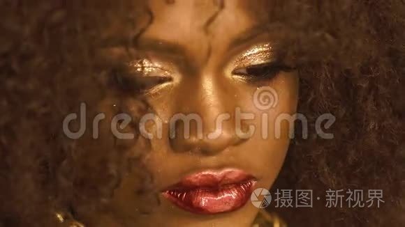 超现实肖像非裔美国女性模特，金色光泽的妆容和大红色的嘴唇。 面子艺术。 创意时尚