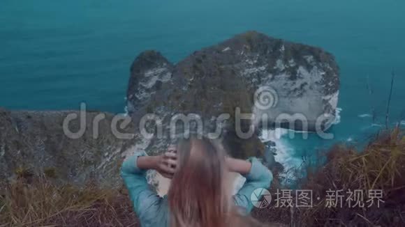 坐在悬崖上欣赏美丽景色的女孩视频