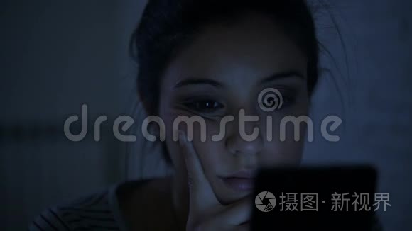 一个30多岁的西班牙裔年轻女子，躺在床上，深夜用手机看着，侧着侧着的平底锅