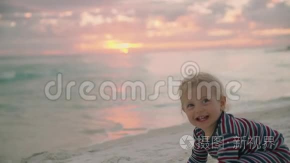 带着玩具在沙滩上爬行的小男孩视频