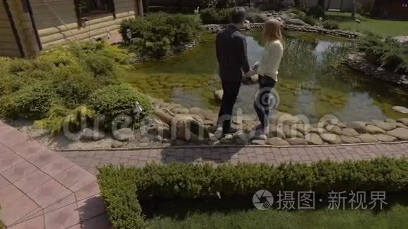 英俊的夫妇走在绿色的花园里视频