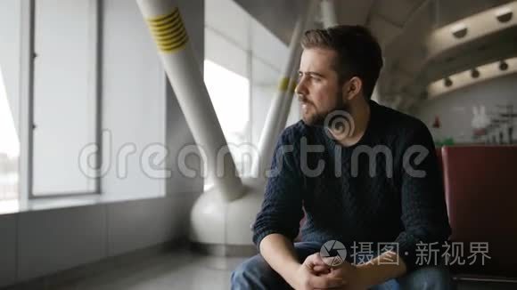 英俊的胡须男坐在机场等待出发视频