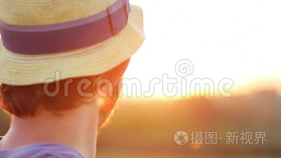 日落时戴帽子的年轻农民画像视频